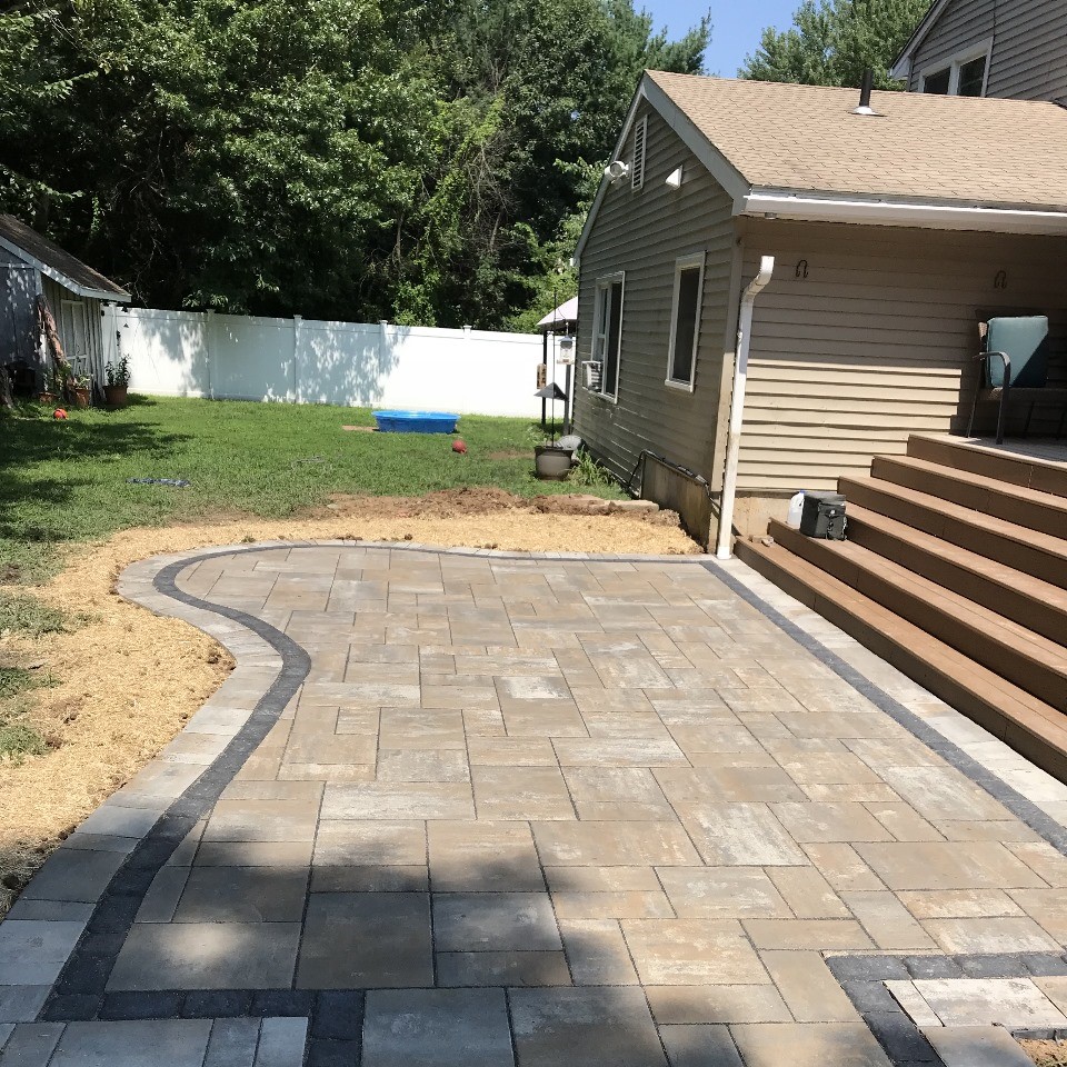 Curved paver patio beside a home