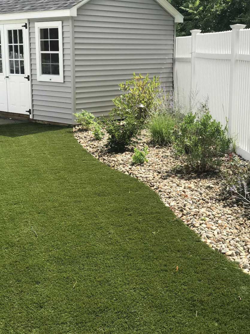 Fresh sod and a planted stone bed